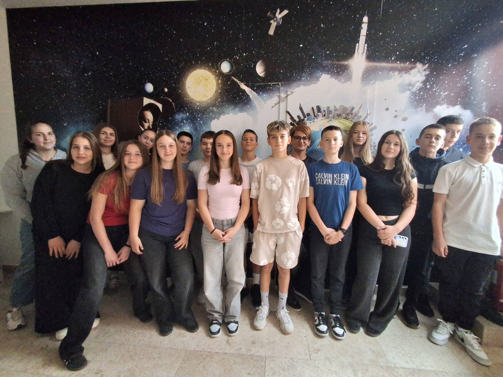 MALI ASTRONOMI POSJETILI REGIONALNI ZNANSTVENI CENTAR Učenici sedmih i osmih razreda Osnovne škole Tenja, polaznici izvnannastavne aktivnosti Mali astronomi, posjetili su 15. svibnja 2026. godine Regionalni znanstveni centar u Josipovcu Punitovačkom. Ovo edukativno putovanje pružilo im je priliku da svoje teorijsko znanje iz učionice primijene u praksi i dožive znanost na potpuno novi način. Dan ispunjen otkrićima i tehnologijom u RZC-u pokazao se kao savršeno mjesto za mlade istraživače. Predavanje o astronomiji, promatranje neba i planetarij približavaju učenicima i odraslima tajne univerzuma te potiču zanimanje za znanost i istraživanje. Glavni naglasci posjeta uključivali su promatranje Sunca i planetarij. Učenici su pozitivno reagirali na sadržaje povezane s univerzumom. Posebno ih se dojmio Planetarij i mogućnost da na zabavan i interaktivan način uče o zvijezdama, planetima i galaksijama. Svrha posjeta bila je promovirati znanost te potaknuti interes učenika za znanost, istraživanje i nova otkrića. Voditeljica puta bile su učiteljica Matematike Tamara Lajoš, koja je ujedno i stručna suradnica RCZ-a Panonska Hrvatska te učiteljica Fizike Gordana Panjkov.